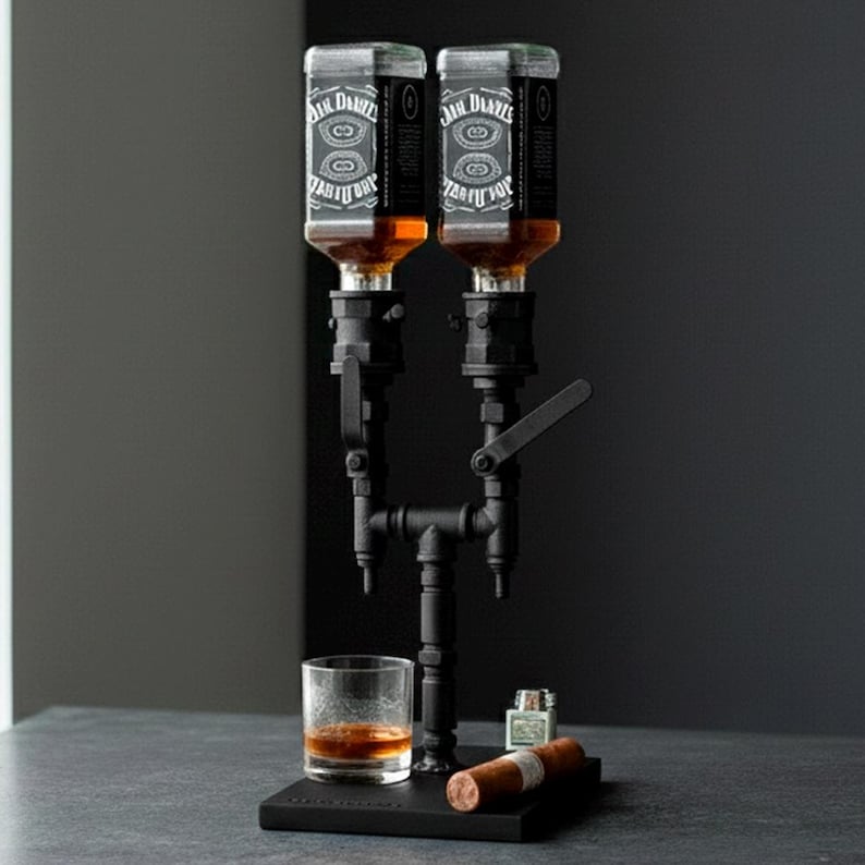 May include: A black metal liquor dispenser with two bottles of Jack Daniel's whiskey. A glass of whiskey, a cigar, and a lighter are on the base. The dispenser has a pipe-like design.