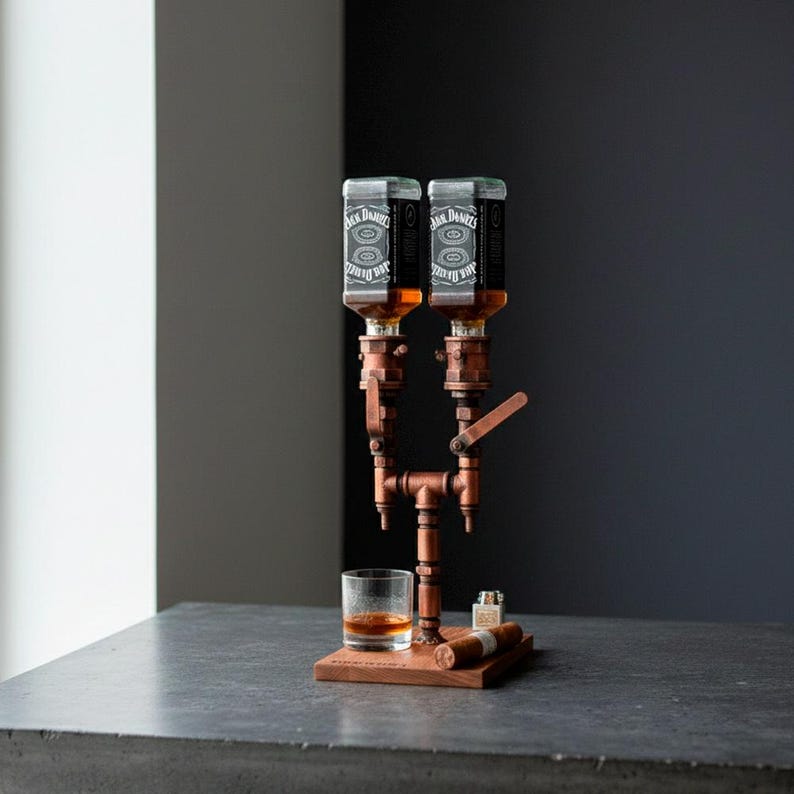 May include: A copper-colored liquor dispenser with two bottles, a glass of amber liquid, and a wooden base. The dispenser has a pipe-like design with a lever and is accompanied by a lighter and two cigars.