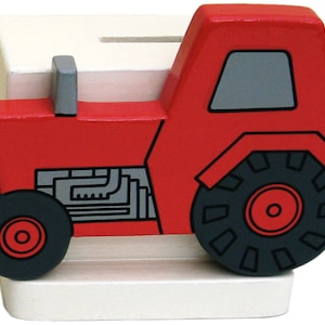 May include: Red wooden tractor money box with a white base. The tractor has a black engine and wheels.