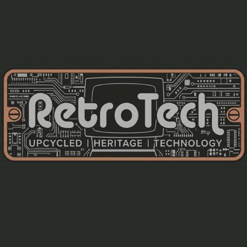May include: A rectangular plaque with a copper-colored border and a black background featuring a white circuit board pattern. The text RetroTech is centered above the words UPCYCLED | HERITAGE | TECHNOLOGY, with a stylized television icon.