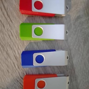 May include: Four USB flash drives arranged vertically, each featuring a colored plastic body in red, lime green, blue, or orange, paired with a swiveling silver metal protective cover that has a circular cutout revealing the color underneath.