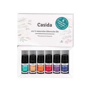 Könnte beinhalten: Eine weiße Box mit einem grünen Kreis, der die Zahl 6 und den Text "fertige Duft-mischungen im Set" enthält. Die Box enthält sechs kleine Flaschen mit ätherischen Ölen, die mit Etiketten in deutscher Sprache versehen sind. Die Etiketten enthalten den Markennamen "Casida" und Beschreibungen wie "Konzentration & Fokus" und "Schlaf schön". Die Box ist von einem weißen Hintergrund umgeben.