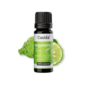 May include: A small, dark brown glass bottle with a black cap, labelled "Casida Bergamotte Öl Citrus bergamia  Ätherisches Öl  Therapeutische Qualität 100% naturrein". The bottle is sitting on a green bergamot fruit.