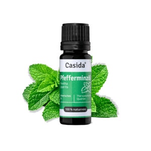 Könnte beinhalten: Eine kleine, dunkelbraune Glasflasche mit schwarzem Verschluss, beschriftet mit "Casida® Pfefferminzöl Mentha piperita Ätherisches Öl Therapeutische Qualität 100% naturrein". Die Flasche ist von grünen Minzblättern umgeben.