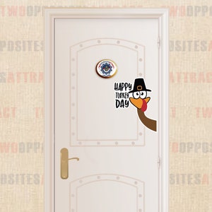 May include: A white door with a Happy Turkey Day sign and a cartoon turkey peeking out from behind the door. The turkey is wearing a pilgrim hat and has a red wattle.
