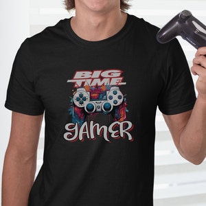 May include: Black t-shirt with a colorful graphic of a video game controller and the text "BIG TIME GAMER".