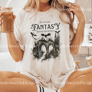 May include: A white t-shirt featuring a black graphic print of a gothic archway with bats and the text "The Tortured Fantasy Readers Department".