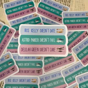 May include: Three stickers with a teal, green, and purple background. Each sticker has a different quote in white text. The top sticker says "Iris Kelly Doesn't Date". The middle sticker says "Astrid Parker Doesn't Fail". The bottom sticker says "Delilah Green Doesn't Care".