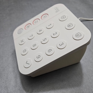 May include: White Ring Alarm keypad with a numeric keypad, a few buttons with icons, and the word "ring" printed on the top.