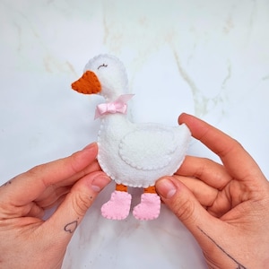 May include: A handmade wooden sign with the text "Welcome to our home" in a handwritten style. The sign is painted white with black lettering and a distressed finish, perfect for home decor.