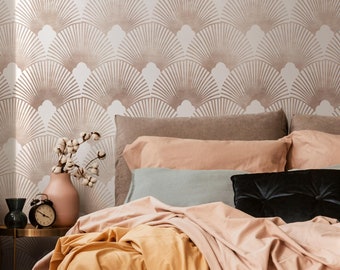 May include: A bed with a peach-colored headboard and a white and brown geometric patterned wallpaper. The bed is made with a peach-colored duvet, a yellow blanket, and a black pillow.