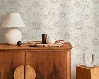 May include: A wooden cabinet with a round door handle, topped with a woven tray holding a small vase and a dark brown cylindrical object. A white lamp with a textured base sits on the cabinet. The background features a repeating pattern of suns, moons, and diamonds.
