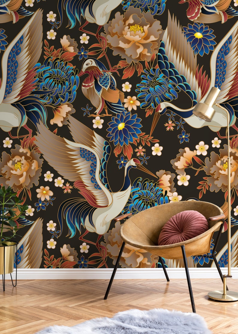 May include: A black background with a repeating pattern of white cranes with blue and gold accents, red and gold flowers, and blue and gold chrysanthemums. The pattern is repeated on a wall behind a brown chair with a red cushion.