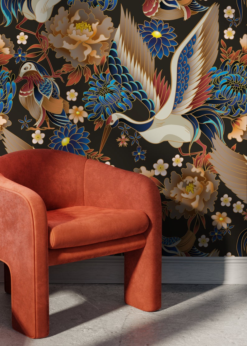 May include: An orange velvet armchair sits in front of a black background with a floral pattern. The pattern features white, blue, and gold cranes, peonies, and chrysanthemums.