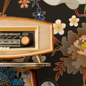 May include: A vintage-style radio with a woodgrain finish sits on a wooden table in front of a black background with a floral pattern. The pattern features cranes, flowers, and leaves in shades of blue, red, gold, and white.