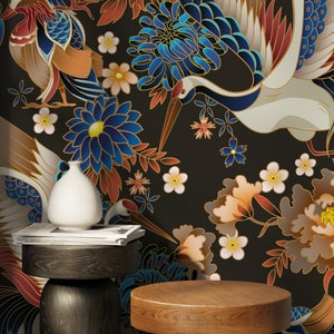 May include: Two wooden side tables with round tops, one dark brown and one light brown, in front of a black background with a floral pattern featuring cranes, flowers, and leaves in shades of blue, gold, red, and white.