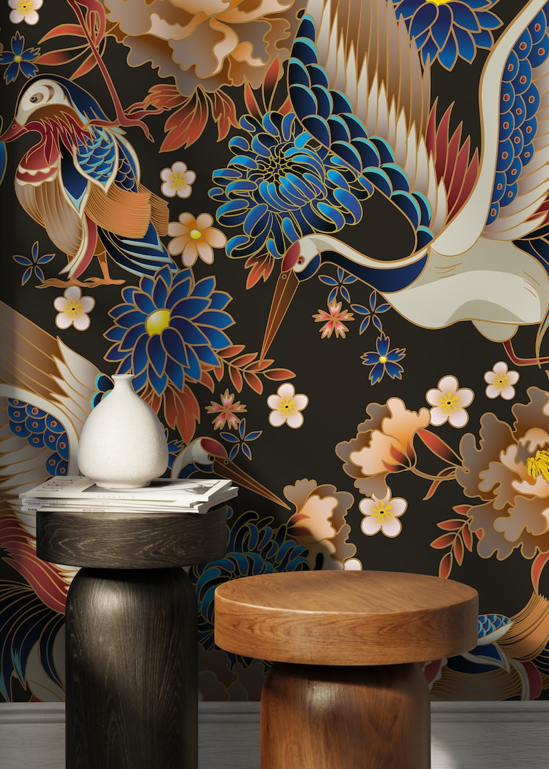 May include: Two wooden side tables with round tops, one dark brown and one light brown, in front of a black background with a floral pattern featuring cranes, flowers, and leaves in shades of blue, gold, red, and white.