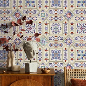 May include: Decorative wallpaper featuring a repeating pattern of ornate, geometric tiles in shades of blue, red, and cream. The design includes floral and scroll motifs, creating a vintage aesthetic. The wallpaper is displayed behind a wooden cabinet with decorative items.