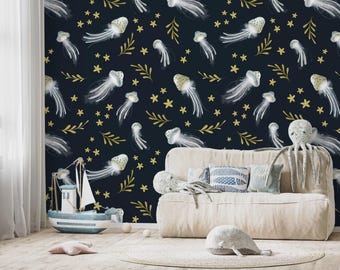 May include: A navy blue wall with a repeating pattern of white jellyfish, gold stars, and leafy sprigs. A beige sofa with decorative pillows and stuffed animals sits in front of the wall. A toy sailboat is on the floor.