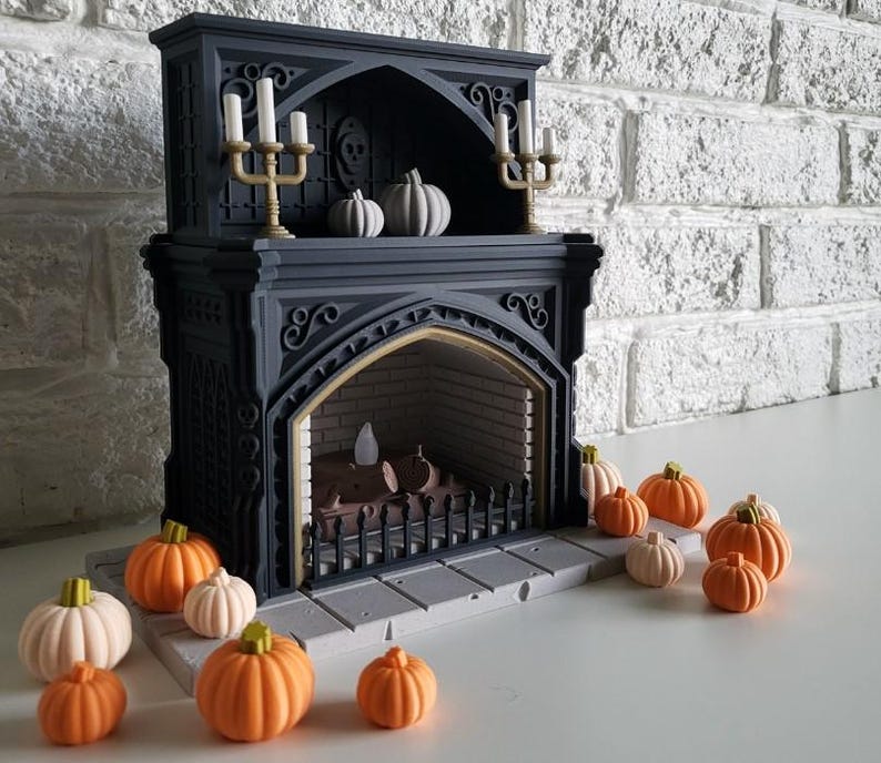 Puede incluir: Una chimenea de estilo g&oacute;tico negro con una rejilla de hierro decorativa y un hogar. La chimenea est&aacute; decorada con peque&ntilde;as calabazas blancas y velas. Hay varias calabazas peque&ntilde;as de color naranja en el suelo frente a la chimenea.