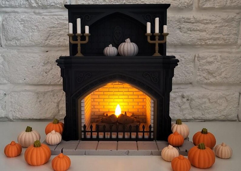 Puede incluir: Una chimenea negra con una chimenea encendida y dos juegos de candelabros con velas blancas. La chimenea est&aacute; decorada con tres calabazas blancas y rodeada de calabazas naranjas y blancas.