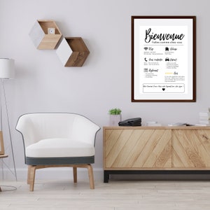 May include: A framed print with the word "Bienvenue" in elegant script. The print includes contact information, Wi-Fi details, and other guest amenities. The frame is dark brown, and the print is displayed in a modern living room setting.