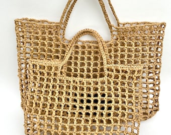 May include: Two tan tote bags crafted from woven natural fiber with an open grid pattern. Each bag features a rectangular base and two sturdy handles at the top. The bags are stacked with the smaller one positioned in front of the larger one.
