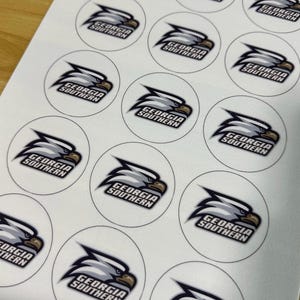 May include: A sheet of circular stickers featuring the Georgia Southern eagle logo. Each white sticker displays a stylized grey and white eagle head in profile facing right, with the text Georgia Southern printed in black beneath the eagle.