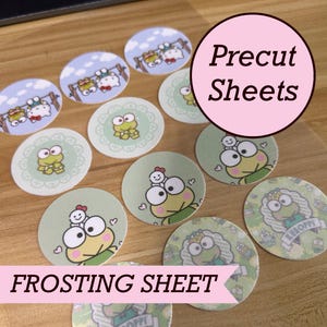 May include: A collection of circular edible frosting sheet toppers featuring various illustrations of Keroppi and Hello Kitty characters. The images include Keroppi in different poses and scenes, printed on a thin, flat, precut sheet material.