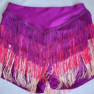 Può includere: Shorts da ballo viola con un bordo a frangia a strati in rosa, bianco e viola.