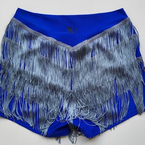 Può includere: Shorts blu reale con un bordo a frangia a strati in un colore blu chiaro.