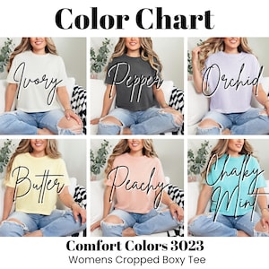 May include: Color chart showcasing six different colored cropped boxy tees. The colors are Ivory, Pepper, Orchid, Butter, Peachy, and Chalky Mint. The text "Comfort Colors 3023 Womens Cropped Boxy Tee" is displayed at the bottom of the image.