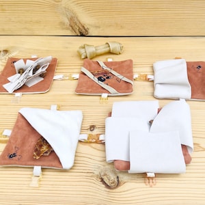 Può includere: Un giocattolo puzzle per cani con cinque scomparti diversi. Ogni scomparto ha un design diverso e può essere utilizzato per nascondere leccornie o giocattoli. Il giocattolo è fatto di tessuto marrone e bianco e ha un giocattolo da masticare a forma di osso.