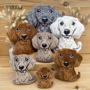 May include: A collection of plush dachshund dog toys in various sizes and colors, including brown, gray, and cream. The toys have detailed facial features and are arranged on a wooden surface. The brand name "naduuu" is visible in the top left corner.