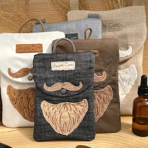 Könnte beinhalten: Vier kleine Beutel mit dem gestickten Text "Beard Care". Die Beutel sind aus verschiedenen Stoffen gefertigt, darunter Denim, Leinen und Baumwolle. Die Beutel sind mit gestickten Schnurrbärten und Bärten verziert. Eine kleine Flasche Bartöl ist ebenfalls abgebildet.