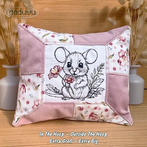 Peut inclure: Un coussin carré décoratif avec un motif patchwork. Le centre présente une illustration brodée d'une souris tenant une fleur. Le coussin a une bordure rose et des accents de tissu à motifs floraux. Le texte "In The Hoop - Outside The Hoop Extra Groß - Extra Big" est en bas.