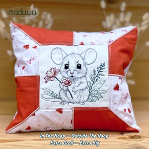 Könnte beinhalten: Quadratisches Zierkissen mit Patchwork-Design. Es zeigt ein gesticktes Bild einer Maus, die eine Blume hält. Das Kissen hat rote und weiße Paneele mit Schmetterlingsmustern. Der Text "In The Hoop - Outside The Hoop Extra Groß - Extra Big" befindet sich unten.