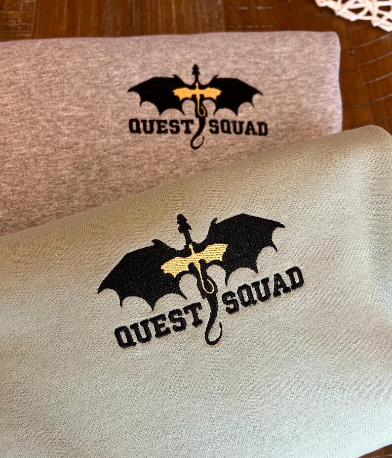 May include: Two sweatshirts with a black dragon graphic and the text "QUEST SQUAD" embroidered in yellow. The top sweatshirt is gray and the bottom sweatshirt is green.