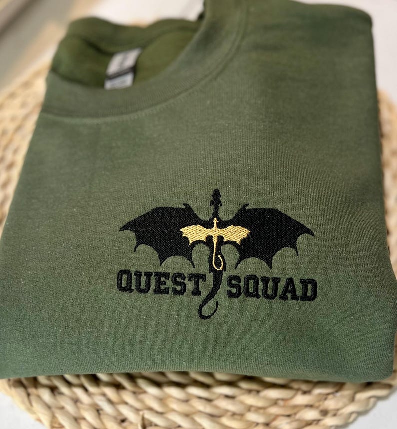 May include: A green sweatshirt with a black dragon and the text "QUEST SQUAD" embroidered in gold thread.