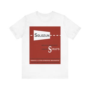 May include: White t-shirt with a red graphic design featuring the text "SOLO'S" and "SPECIALE BRANDSTOF" with a red and white design of a fuel pump with the text "SOLOZIJN" above it. The text "INHOUD 2 LITER GEMENGE BRANDSTOF VOOR HET GEBRUIK SCHUDDEN" is below the graphic.