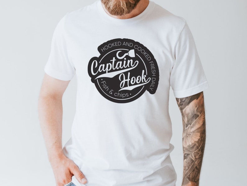 May include: White t-shirt with a black and white logo that says "Hooked and Cooked Fresh Daily Captain Hook Fish & Chips".