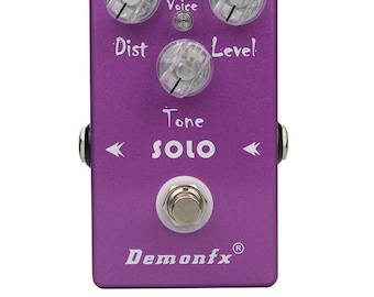 以下が含まれることがあります： 前面に「SOLO」と「Demonfx」の文字が書かれた紫色のギターエフェクトペダル。ペダルには、「Voice」、「Dist」、「Level」、「Tone」というラベルの付いた4つのノブがあります。