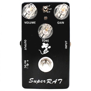 Puede incluir: Pedal de guitarra negro Super Rat 7 con perillas etiquetadas como "Volumen", "Tono" y "Ganancia". El pedal tiene un gráfico de ratón blanco y el texto "Super RAT 7" en blanco.
