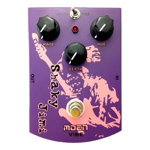 May include: Purple and pink electric guitar effects pedal with the text "Shaky Jimi" and "MOEN VIBE". The pedal has four knobs labeled "Rate", "Depth", "Hue", and "Chorus/Vibe".