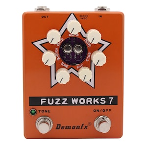 May include: An orange guitar effects pedal with the text "FUZZ WORKS 7" and the brand name "Demonfx" in black lettering. The pedal has six knobs labelled "Gate", "Volume", "Comp", "Tone", "Fat", "Drive", and "Stab".