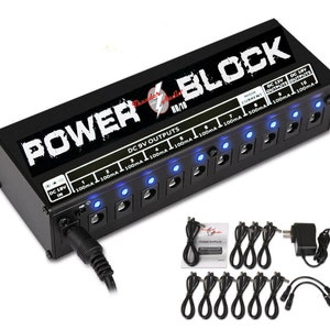 May include: Black power supply unit with the text "POWER BLOCK" in white. It has 10 outputs with blue LED lights and a DC 18V input. The unit comes with 10 black cables with different connectors.