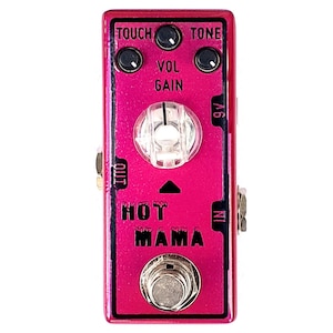 May include: A pink guitar effects pedal with the text "HOT MAMA" on the front. The pedal has knobs labelled "TOUCH", "TONE", "VOL", and "GAIN".