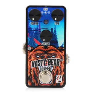 May include: A black and blue guitar pedal with a bear illustration and the text "Nasty Bear Fuzz" on the front. The pedal has three knobs labeled "Volume", "Sustain", and "Tone".