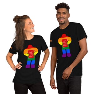 May include: Two people wearing black t-shirts with a rainbow colored figure holding a red sign that says "Keep Calm Got A Golem".