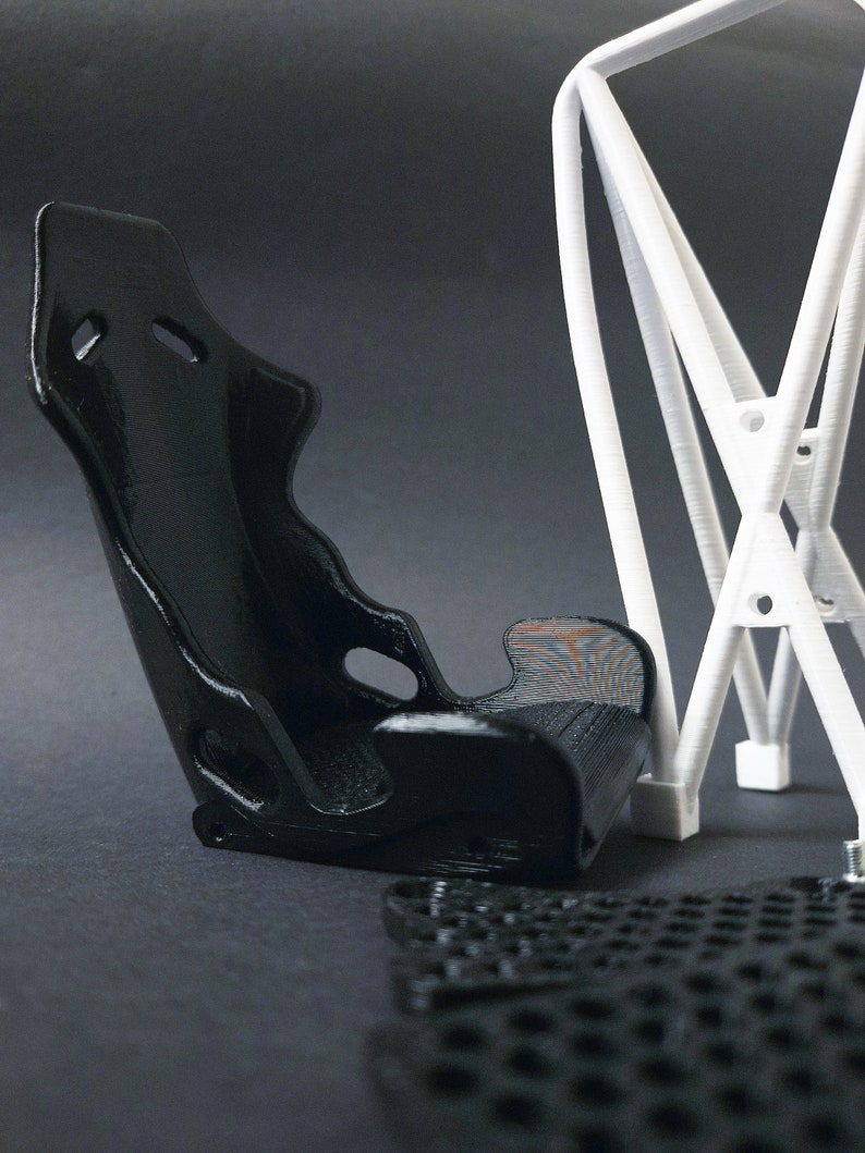 Transform your workspace with this incredible customizable DIY racing seat phone holder kit. It features an unassembled roll cage design that allows you to create a unique and stylish phone stand for your desk. Elevate your workspace today! Nine3D